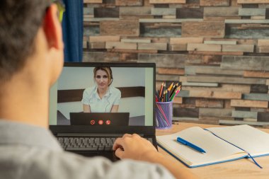 Student learning by video conferencing, online training, and distance education. Schoolboy uses the laptop for online lessons clipart