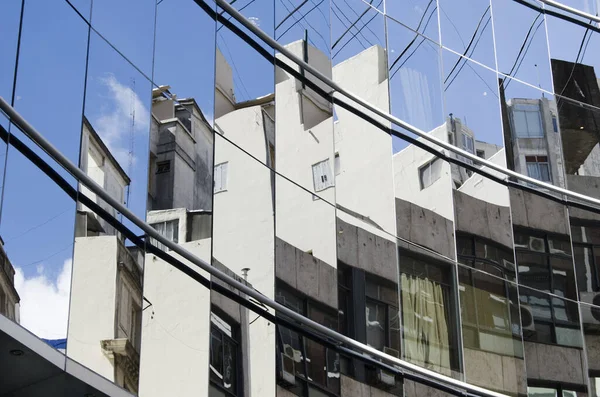 Verglastes Gebäude, das seltsame Reflexionen der umliegenden Gebäude erzeugt — Stockfoto