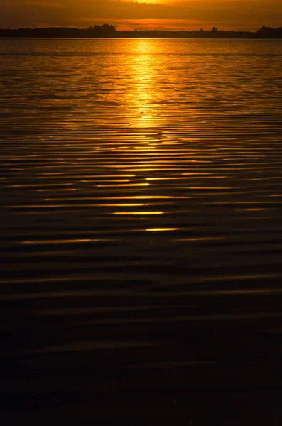 Pôr do sol em Chascomus, o sol alaranjado é refletido na superfície do lago — Fotografia de Stock