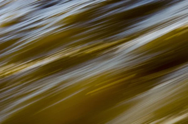 Textura de água em movimento rápido, em tons amarelados . — Fotografia de Stock