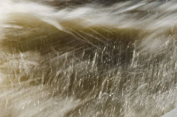 Textura de agua en movimiento rápido, en tonos amarillentos . —  Fotos de Stock