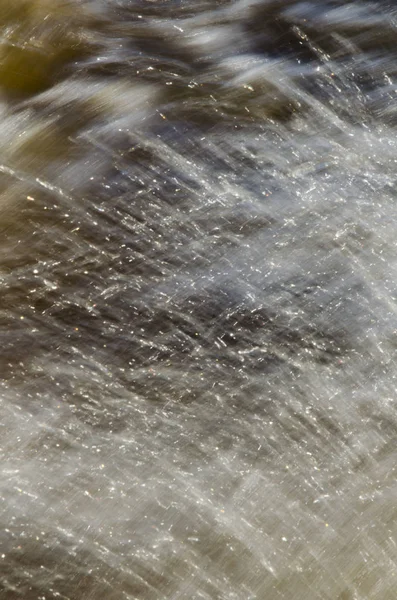 Textura de agua en movimiento rápido, en tonos amarillentos . —  Fotos de Stock