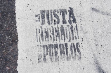 Capital Federal, Buenos Aires / Argentina; Sept 2, 2016: message written with stencil in the street, in a mass demonstration against the government: The just rebellion of the peoples
