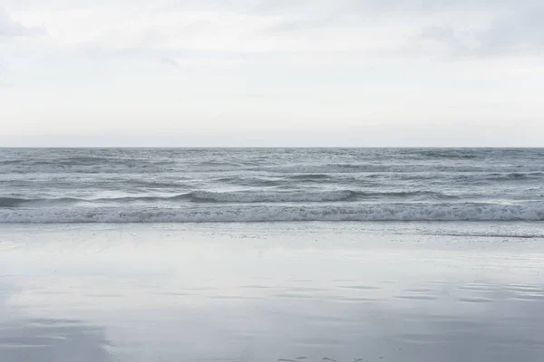 Plaża Krajobraz Spokojne Morze Zachmurzone Niebo Odzwierciedlone Mokrym Piasku Brzegu — Zdjęcie stockowe