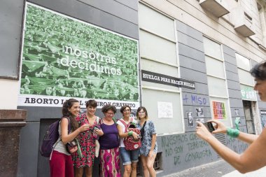 CABA, Buenos Aires / Argentina; March 9, 2020: international women's day. Women taking a picture in front of a feminist cartel, in defense of legal, safe and free abortion