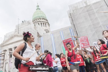 Caba, Buenos Aires / Arjantin; 9 Mart 2020: Uluslararası Kadınlar Günü. Davul çalan ve slogan atan genç kadınlar yasal, güvenli ve ücretsiz kürtaj yasası lehine, Kongre önünde