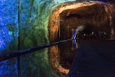 Nemocon, Cundinamarca / Kolombiya; 24 Mart 2018: bir tuz madeninin içindeki renkli ışıklarla aydınlatılmış su ve duvarların aynası, turlara açık