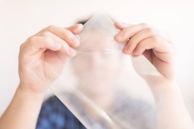 Adam bir asetatın köşelerini kareliyor. Koronavirüsün yayılmasını önlemek için ev yapımı koruyucu maske yapma süreci, Covid-19.