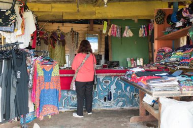 Cabo Polonio, Rocha / Uruguay; 30 Aralık 2018: Turist plaj kasabasındaki bir giyim ve el sanatları mağazasından alışveriş yaparken görülen kadın