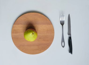 Çatal ve bıçakla tahta tahtada armut.