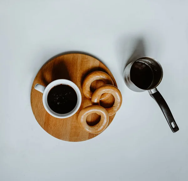 木製の板の上にセブとベーグルを乗せたコーヒーカップ — ストック写真