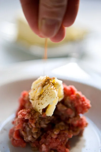 Adding species to the heap of ground meet and butter for cooking