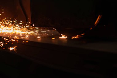 Kıvılcım saçan metal levha. Cnc lazer kesim metal, modern endüstriyel teknoloji. Tamamlanmış parçalar üretiliyor.