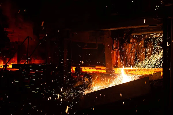 Hot rode stalen knuppels bij zaklamp snijden. Achtergrond van de smid en metaalindustrie. — Stockfoto