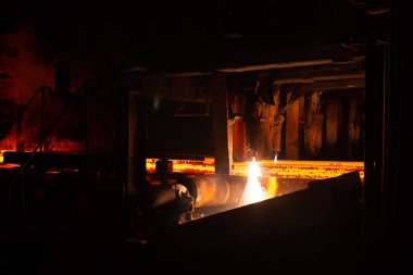 Meşale kesiminde sıcak kırmızı çelik kirişler. Demirci ve metalurji endüstrisinin arka planı.