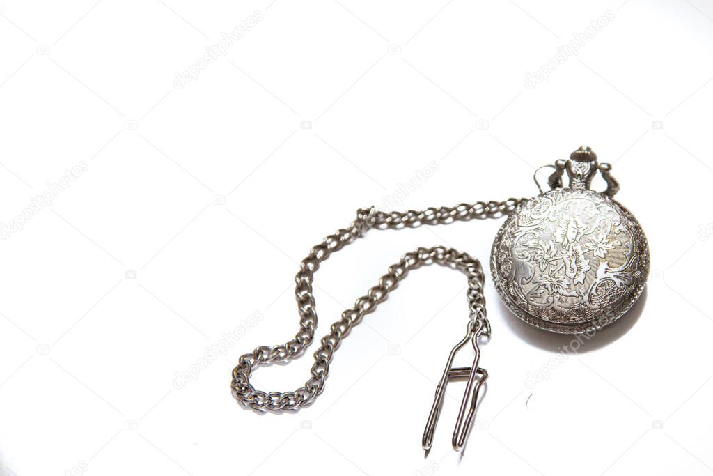 Vintage pocket watch with a chain on white isolated background.