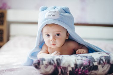 Üç ay boyunca komik şapkalı bir çocuk battaniyeye uzandı. Güzel sarışın bir bebeğin portresi.