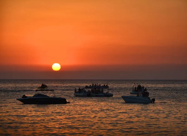 Pessoas assistindo por do sol de barcos — Fotografia de Stock