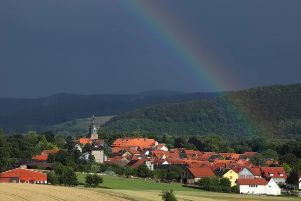 Il villaggio di Herleshausen con un arcobaleno dopo un temporale estivo — Foto Stock