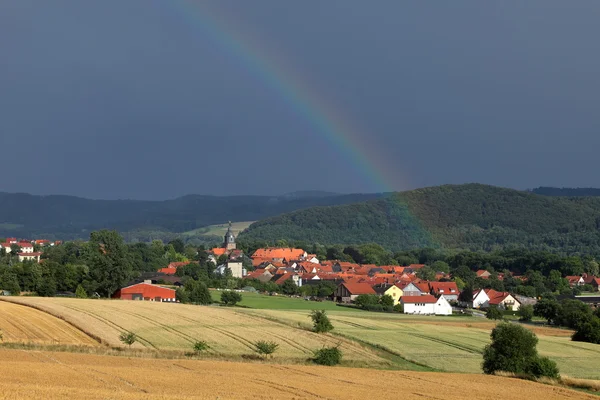 Il villaggio di Herleshausen con un arcobaleno dopo un temporale estivo — Foto Stock