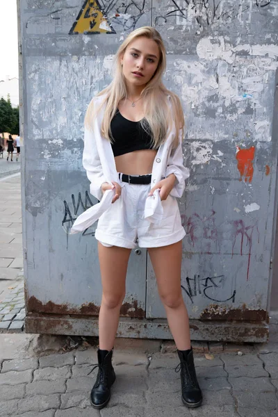 Sensual chica rubia sexy en pantalones cortos blancos y top negro mirando a la cámara —  Fotos de Stock