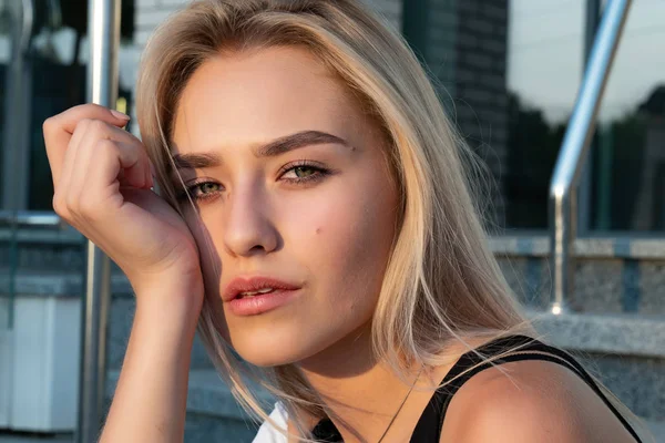 Gros plan portrait d'une jolie fille blonde à la peau claire et naturelle qui regarde la caméra, des rayons de soleil tombent sur son visage — Photo