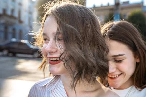 Glücklich lächelnde brünette Mädchen mit gesunder Haut und roten Lippen, die hintereinander stehen — Stockfoto