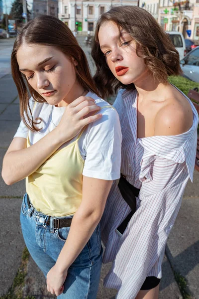 Två unga vackra hipster flickor i casual kläder står mitt på gatan — Stockfoto