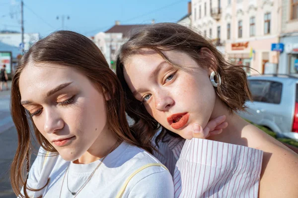 Retrato de cerca de las hermosas chicas hipster con cabello moreno, labios rojos y ojos verdes disfrutando de los días soleados de verano en la ciudad —  Fotos de Stock