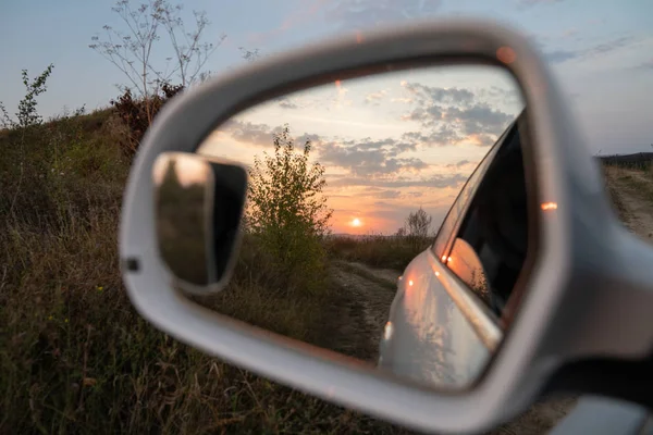 Hermosa puesta de sol se muestra en el espejo lateral del coche —  Fotos de Stock