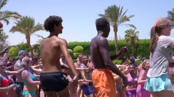 Hurghada, Egipt, 09.08.2019: Międzynarodowa grupa ludzi turyści tańczący dowcipnych animatorów na imprezie tanecznej na plaży — Wideo stockowe