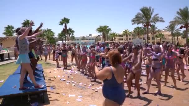 Hurghada, Egypt, 09.08.2019: Sun rise hotel. The animators conducts an entertaining dance physical culture event on the beach — Stock Video