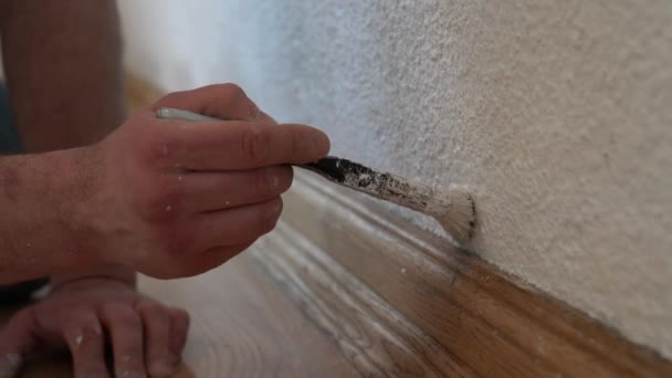 Mans hand met penseel met witte verf op muur, interieur — Stockvideo