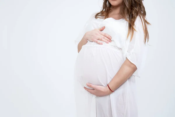 Jeune femme enceinte brune en sous-vêtements blancs tient ses mains sur son ventre gonflé. Concept d'amour. Horizontal avec espace de copie — Photo