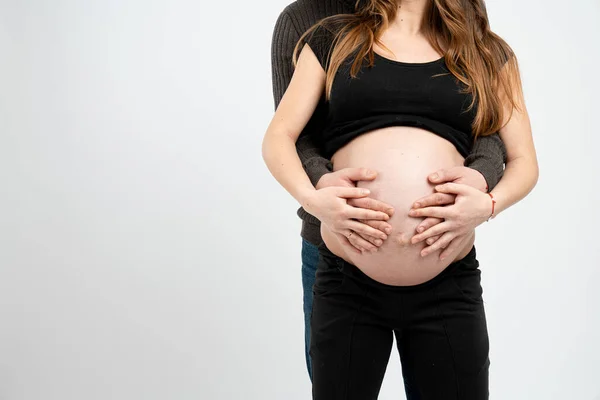 Mains de la mère enceinte et le père debout tenant ventre, concept de jeune famille, isolé sur fond blanc, copyspace pour votre texte — Photo