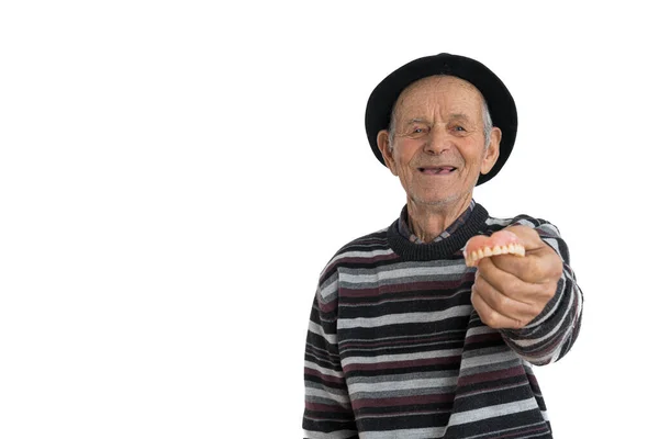 Портрет старого щасливого чоловіка в чорному капелюсі, що показує модель людських зубів і дивиться на камеру, ізольовані на білому тлі — стокове фото