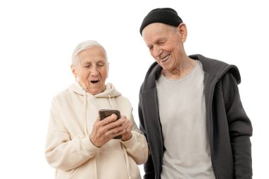Beyaz arka planda akıllı telefonlarını kullanan mutlu, olgun bir çift, kapüşonlu yaşlı adam ve kadın.