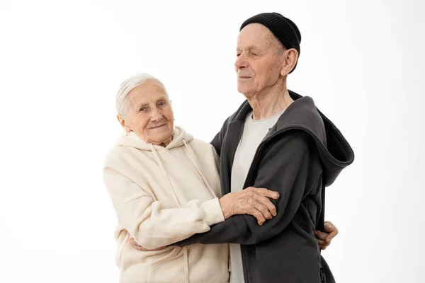 Atractiva pareja de ancianos encantadores en sudaderas con capucha bailando aislados sobre fondo blanco — Foto de Stock