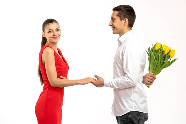 Foto de encantador lindo bonito bastante dulce de moda pareja blanca de dos personas junto con él regalando a su esposa tulipanes amarillos flores y su regocijo con conseguir flores y mirando a la cámara — Foto de Stock