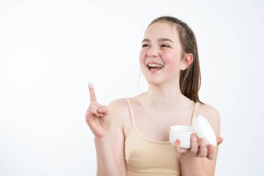 Applying moisturizer cream. Happy smiling young model after bath cares about her face. Photo of woman with perfect skin. Skin care concept