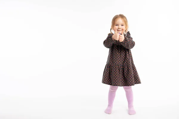 Funny little child over white isolated background approving doing positive gesture with hand, thumbs up smiling and happy for success. Winner gesture. — Stockfoto