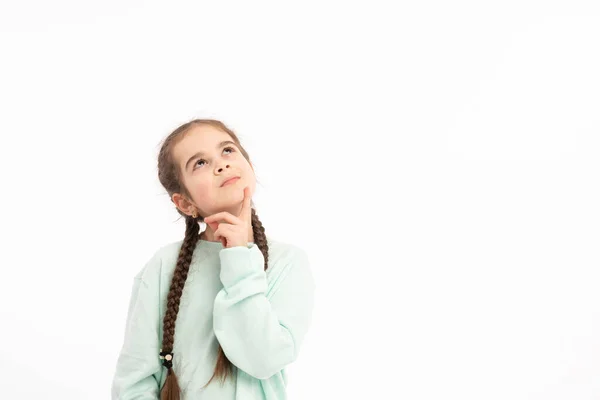 Horizontal portrait of thoughtful puzzled youngster looks with pensive dreamy expression aside, thinks what decision to make, stands against white background — Stockfoto