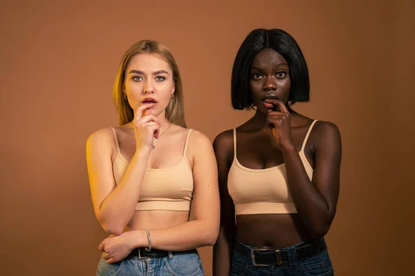 Jeune jolie femme européenne et africaine regardant inquiète, anxieuse, stressée et effrayée, mordant les ongles et regardant la caméra — Photo