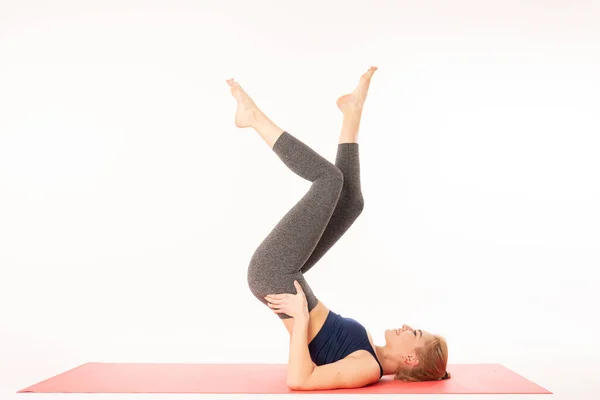 Yoga ve jimnastik yapan genç ve güzel bir kadın. Sağlık konsepti. Tek kişilik spor dersleri. Beyaz arkaplan üzerinde izole edilmiş — Stok fotoğraf