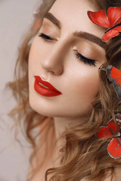 Retrato de moda de belleza de una linda chica misteriosa con mariposas en su pelo rubio rizado, mujer con maquillaje natural y ojos cerrados — Foto de Stock