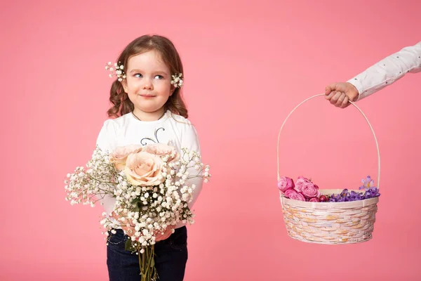 Söta barn som håller våren blommor bukett och titta på handen som håller korg med blommor på vänster sida — Stockfoto