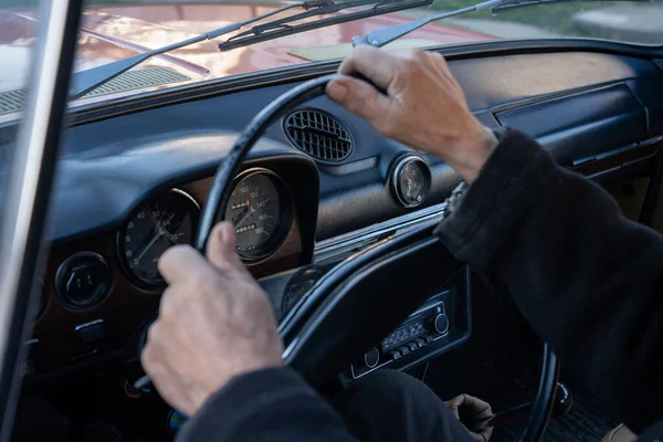 Nerozpoznatelný muž se drží za ruce na volantu a řídí retro auto po venkovské silnici za slunečného podzimního dne. Guy ovládání jeho auto na dálnici na vysoké rychlosti — Stock fotografie