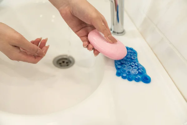 A nő szappant tart és mutat a kezében. Tenyér és ujjak szappanhabban nyújtsa előre a szappant — Stock Fotó