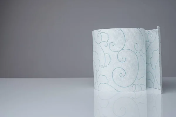 Один рулон туалетной бумаги туалетная бумага стоит на белом столе — стоковое фото