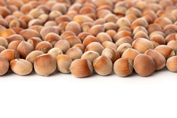 Närbild av skalade hasselnötter isolerade på vitt. Heap av hasselnötter som bakgrund. — Stockfoto
